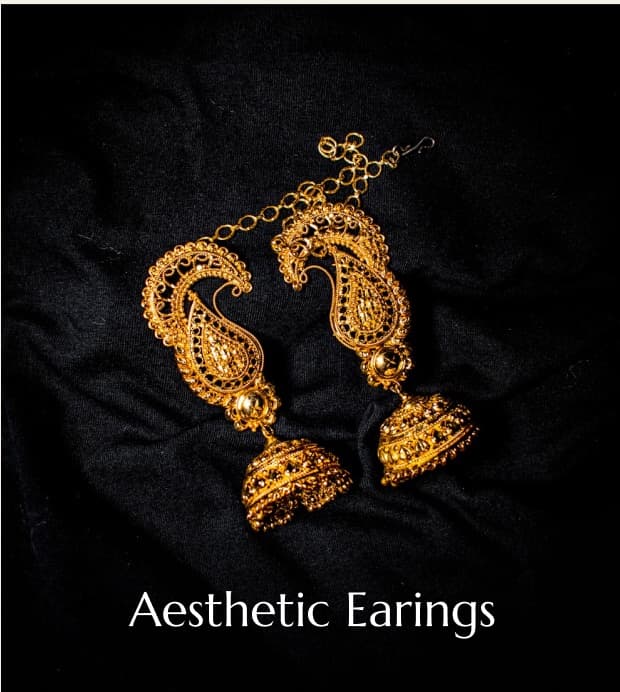 Gold handcrafted earrings on black fabric